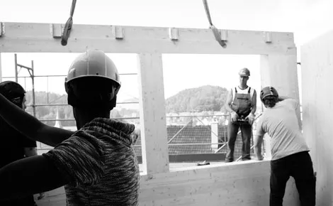 Holz Handwerk Team montiert einen Holzrahmen auf einer Baustelle in St. Gallen